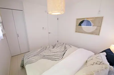 a bedroom with a bed with a striped blanket on it at \u897f\u5de3\u9d28HOUSE in Tokyo