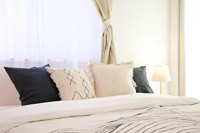 a bedroom with a bed with pillows and a window at \u897f\u5de3\u9d28HOUSE in Tokyo