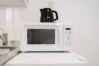a microwave sitting on top of a kitchen counter at Takadanobaba Address102 in Tokyo