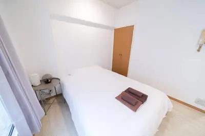 a bedroom with a white bed with a wooden tray on it at Takadanobaba Address102 in Tokyo