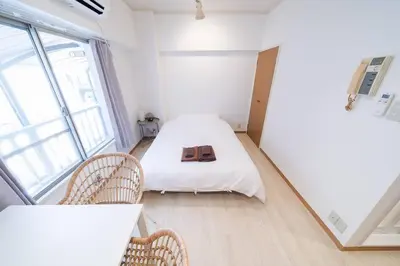 a small room with a bed and two chairs at Takadanobaba Address102 in Tokyo