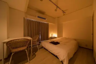 a bedroom with a bed and a table and chairs at Takadanobaba Address102 in Tokyo