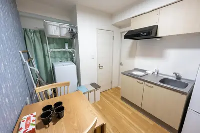 a small kitchen with a table and a refrigerator at \u4eca\u548cHotel in Tokyo