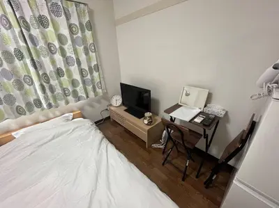 a bedroom with a bed and a desk with a television at \u5c71\u624b\u7dda\u5de3\u9d28\u99c5\u307e\u3067\u5f92\u6b69\uff15\u5206\u306e\u5feb\u9069\u306a\u30ef\u30f3\u30eb\u30fc\u30e0 in Tokyo