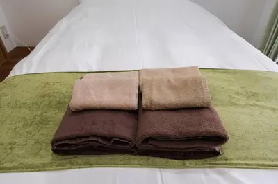 a pile of towels sitting on top of a bed at Shibuya E Address 303 in Tokyo