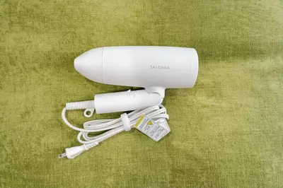 a white hair dryer sitting on a green surface at Shibuya E Address 303 in Tokyo