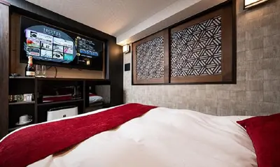 a bedroom with a large bed with a flat screen tv at Hotel Opera in Tokyo
