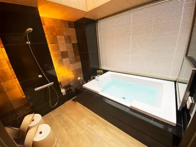 a bathroom with a large tub and a toilet at Hotel Opera in Tokyo