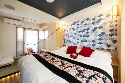 a bedroom with a large bed with red pillows at Hotel Opera in Tokyo