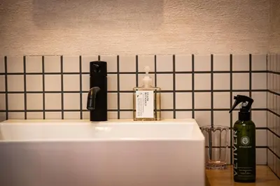 a bathroom sink with a bottle of soap on it at SHITAMACHI PLACE TOKYO in Tokyo