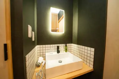 a bathroom with a white sink and a mirror at SHITAMACHI PLACE TOKYO in Tokyo