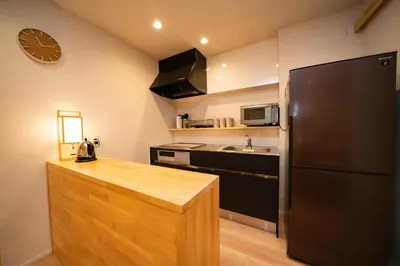 a kitchen with a black refrigerator and a sink at SHITAMACHI PLACE TOKYO in Tokyo