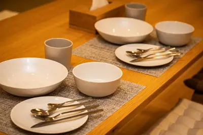 a table with white plates and silverware on it at SHITAMACHI PLACE TOKYO in Tokyo