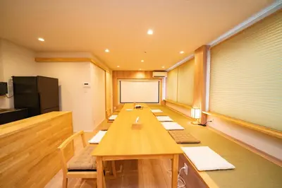 a conference room with a long table and a screen at SHITAMACHI PLACE TOKYO in Tokyo