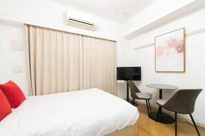 a bedroom with a bed and a table and chairs at Ihatov Komazawa in Tokyo