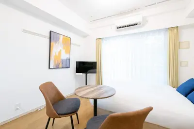 a bedroom with a bed and a table and chairs at Ihatov Komazawa in Tokyo