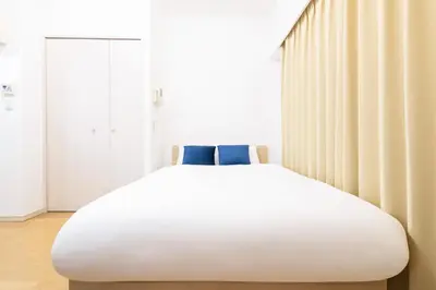a large white bed in a room with a window at Ihatov Komazawa in Tokyo