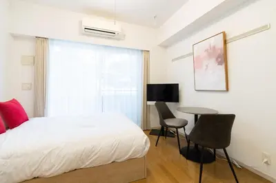 a bedroom with a bed and a table and a window at Ihatov Komazawa in Tokyo