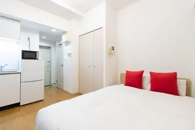 a bedroom with a white bed and red pillows at Ihatov Komazawa in Tokyo