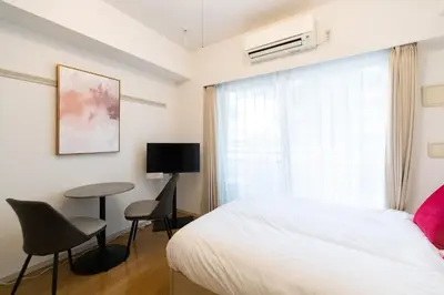 a bedroom with a bed and a table and chairs at Ihatov Komazawa in Tokyo