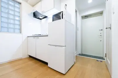 a kitchen with white cabinets and a window at Ihatov Komazawa in Tokyo