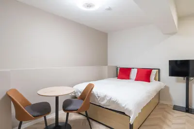 a bedroom with a bed with a table and chairs at The Sanctus \u6075\u6bd4\u5bff in Tokyo