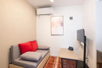 a living room with a couch and a tv at The Sanctus \u6075\u6bd4\u5bff in Tokyo