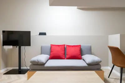 a couch with red pillows in a living room at The Sanctus \u6075\u6bd4\u5bff in Tokyo