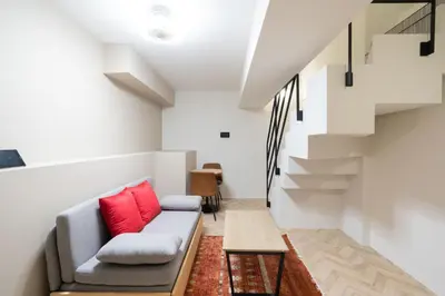 a living room with a couch and stairs at The Sanctus \u6075\u6bd4\u5bff in Tokyo