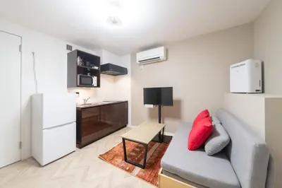 a living room with a couch and a kitchen at The Sanctus \u6075\u6bd4\u5bff in Tokyo