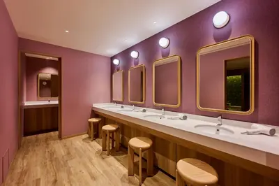 a purple bathroom with three sinks and mirrors at The Royal Park Hotel Ginza 6-Chome in Tokyo