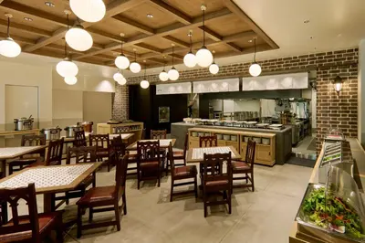 a restaurant with tables and chairs and a kitchen at The Royal Park Hotel Ginza 6-Chome in Tokyo