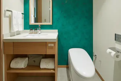 a bathroom with a sink and a toilet and a mirror at The Royal Park Hotel Ginza 6-Chome in Tokyo