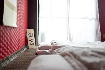 a room with two beds and a sign on the wall at Geisha Expelience Stay in Tokyo