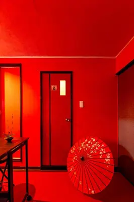 a red room with a red wall and a red umbrella at Geisha Expelience Stay in Tokyo