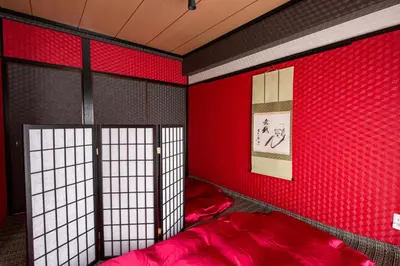 a red room with a bed with red sheets at Geisha Expelience Stay in Tokyo