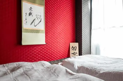 a bedroom with two beds and a painting on the wall at Geisha Expelience Stay in Tokyo