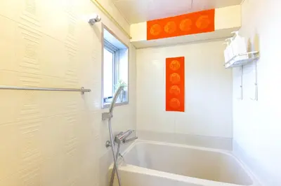 a white bathroom with a tub and a window at Geisha Expelience Stay in Tokyo