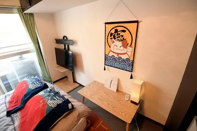 a room with a bed and a table and a tv at \u65b0\u5bbfJAPANNING\u30cf\u30a6\u30b9 in Tokyo