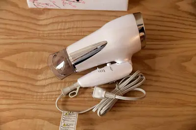 a hair dryer sitting on top of a wooden table at \u65b0\u5bbfJAPANNING\u30cf\u30a6\u30b9 in Tokyo