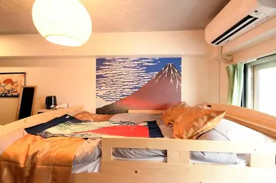 a bedroom with a bed with a mountain mural on the wall at \u65b0\u5bbfJAPANNING\u30cf\u30a6\u30b9 in Tokyo