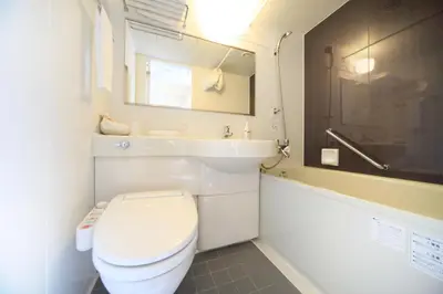 a bathroom with a toilet and a sink and a tub at Sotetsu Fresa Inn Shimbashi-Karasumoriguchi in Tokyo
