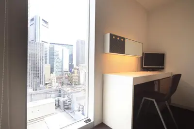 a room with a desk with a computer and a window at Sotetsu Fresa Inn Shimbashi-Karasumoriguchi in Tokyo