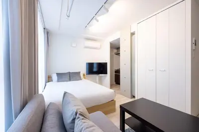 a bedroom with a bed and a couch and a table at KiSETSU\u65e9\u7a32\u7530II in Tokyo
