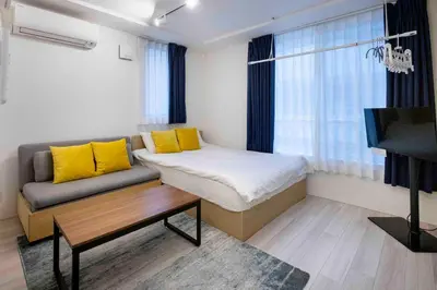 a small room with a bed and a couch at KiSETSU\u65e9\u7a32\u7530II in Tokyo