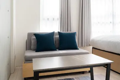 a living room with a couch and a bed at KiSETSU\u65e9\u7a32\u7530II in Tokyo