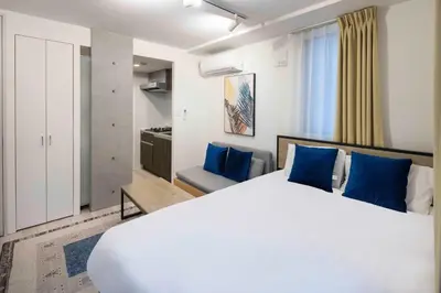 a bedroom with a large white bed and blue pillows at KiSETSU\u65e9\u7a32\u7530II in Tokyo