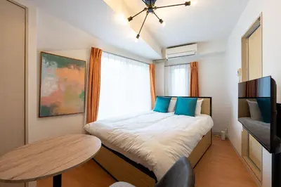 a small bedroom with a bed and a table at S-K MANSION in Tokyo