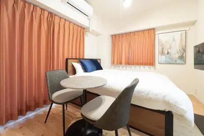 a bedroom with a bed and a table and chairs at S-K MANSION in Tokyo