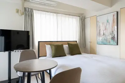a bedroom with a bed and a table and a tv at S-K MANSION in Tokyo